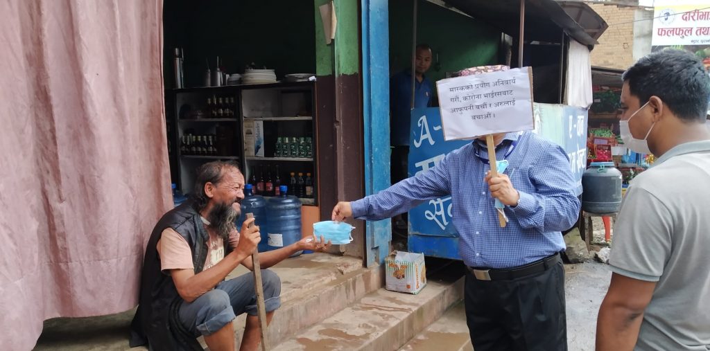 cdo nuwakot jhankanath dhakal giving a mask to civil