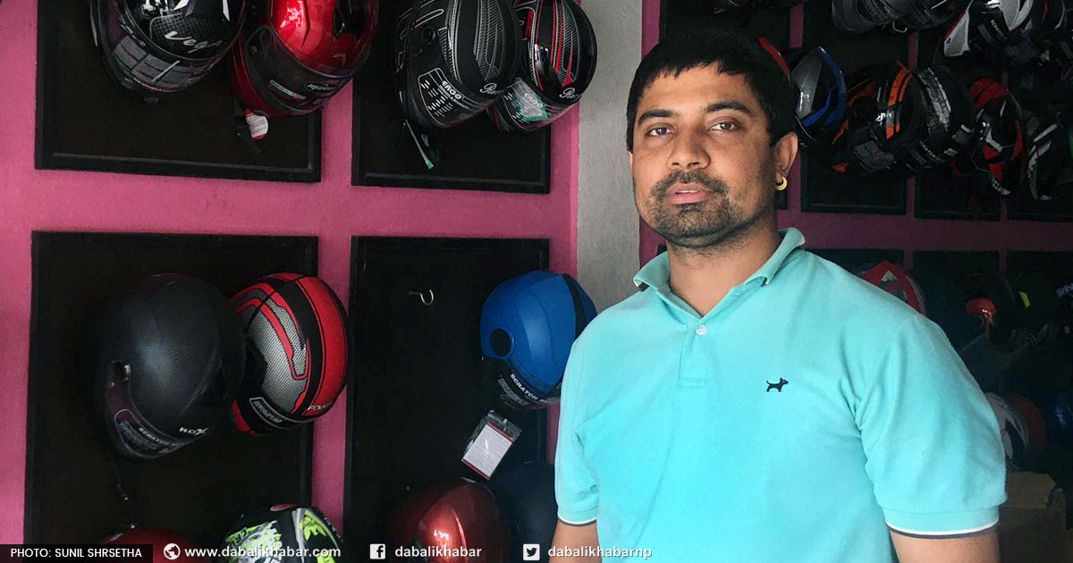 owner kiran bhatta standing in helmets showroom nuwakot