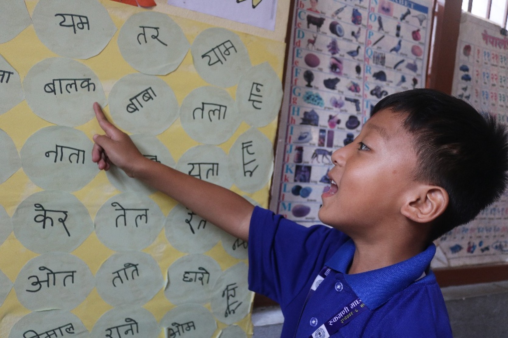 Children run around searching for the letters stuck on the walls.